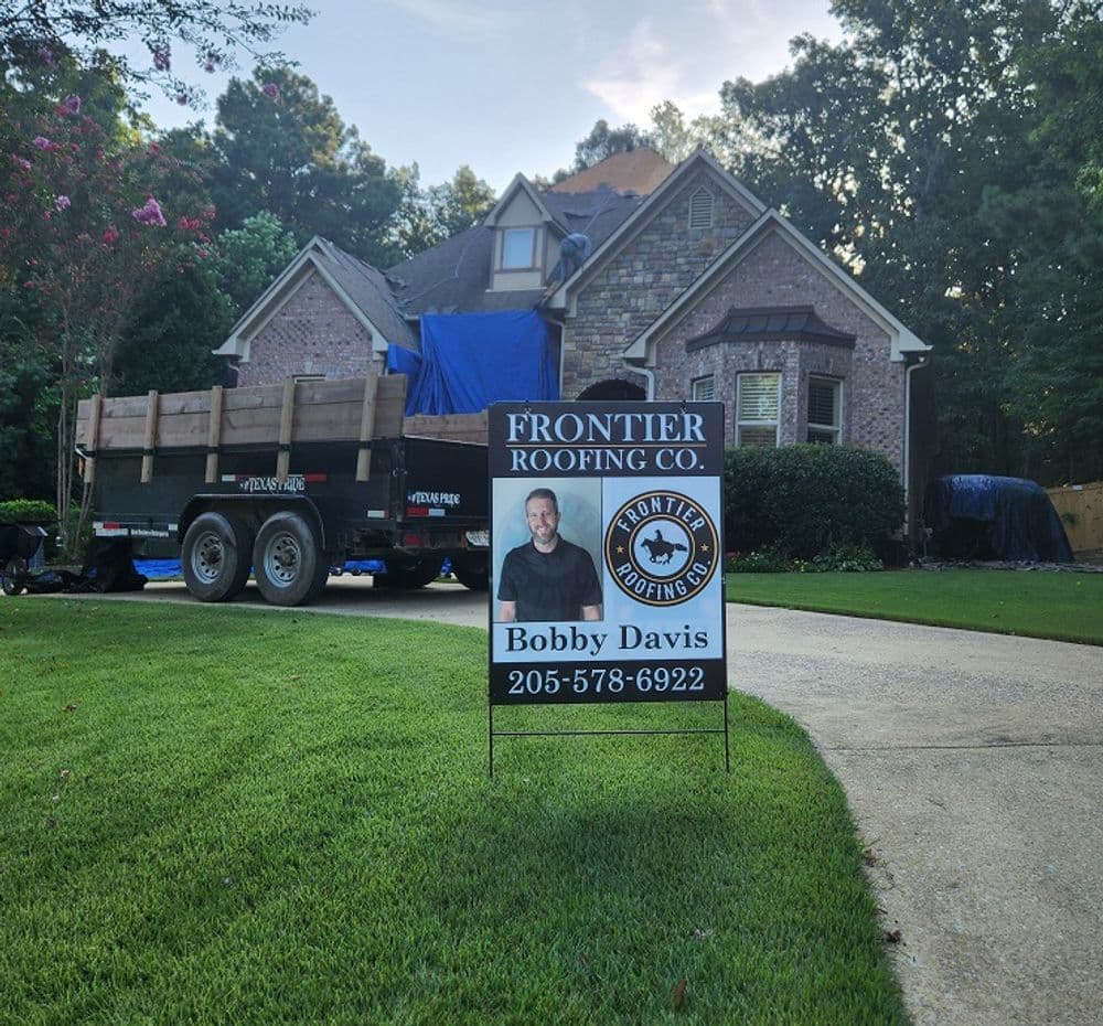 Frontier Roofing Co. yard sign in front of a residential home with a roofing project underway.
