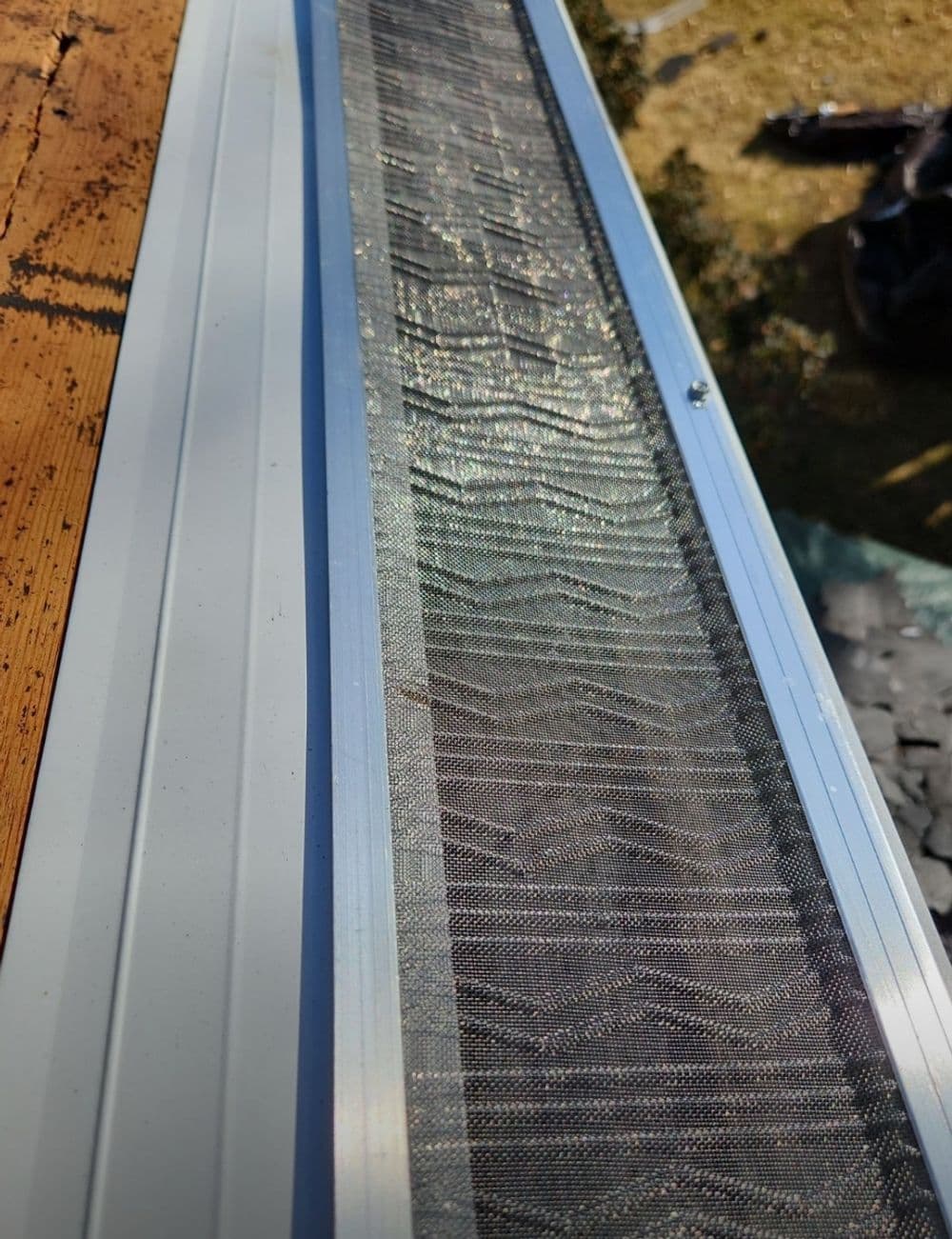 Gutter guard installation on a home, showcasing mesh screening for debris protection.