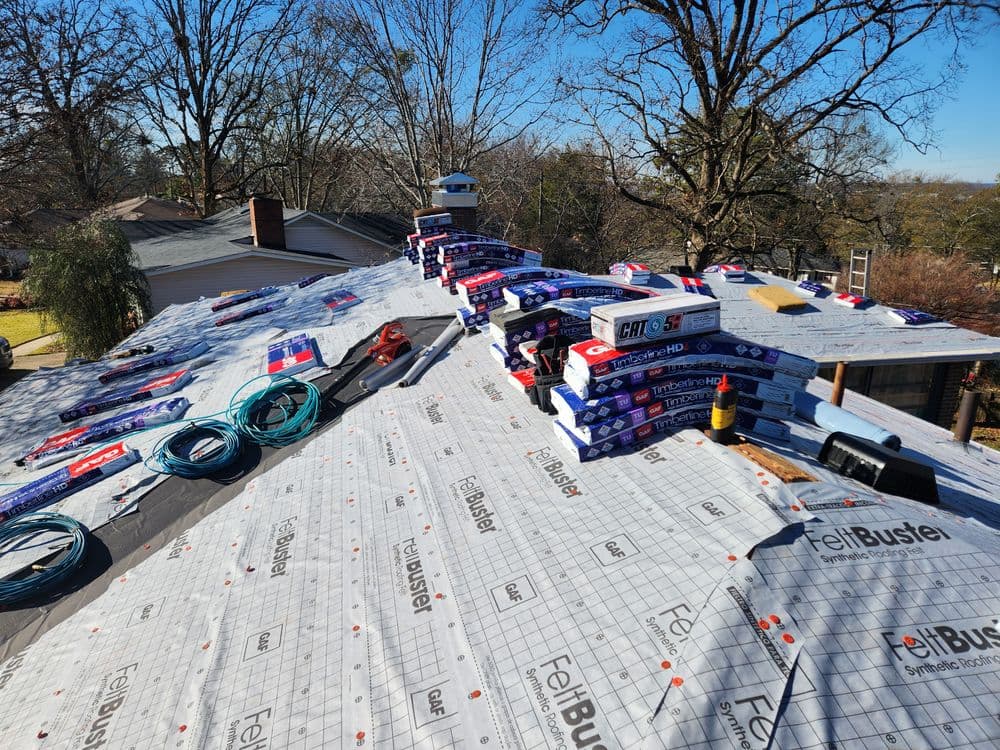 Roofing materials and tools arranged on a residential roof, ready for installation.